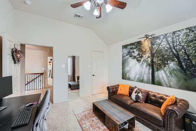 Living area featuring a ceiling fan, vaulted ceiling, and speckle patterned floor | Image 26