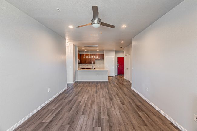 Unfurnished living room with dark wood-style floors, a ceiling fan, and recessed lighting | Image 5