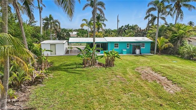 Back of house featuring a yard and a storage shed | Image 4