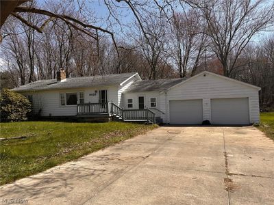 Single story home featuring covered porch, a garage, and a front yard | Image 1