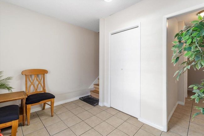 Living area featuring stairway, light tile patterned flooring, and baseboards | Image 5