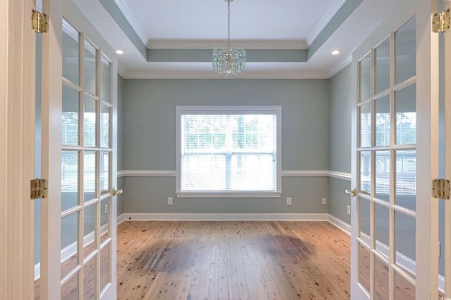 Spare room with ornamental molding, hardwood / wood-style flooring, a chandelier, french doors, and a tray ceiling | Image 8