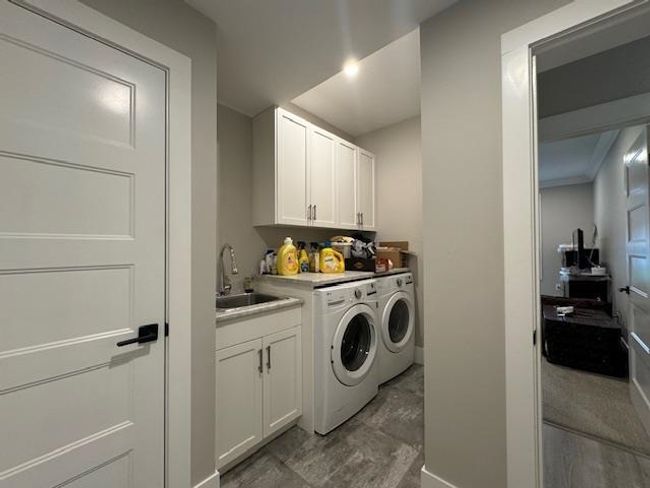 Washroom with washer and dryer, baseboards, a sink, and cabinet space | Image 24