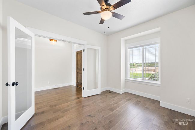 Empty room featuring wood finished floors, a ceiling fan, and french doors | Image 23