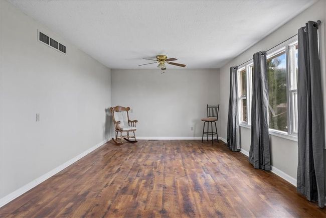 Spare room featuring baseboards, ceiling fan, visible vents, and wood finished floors | Image 52