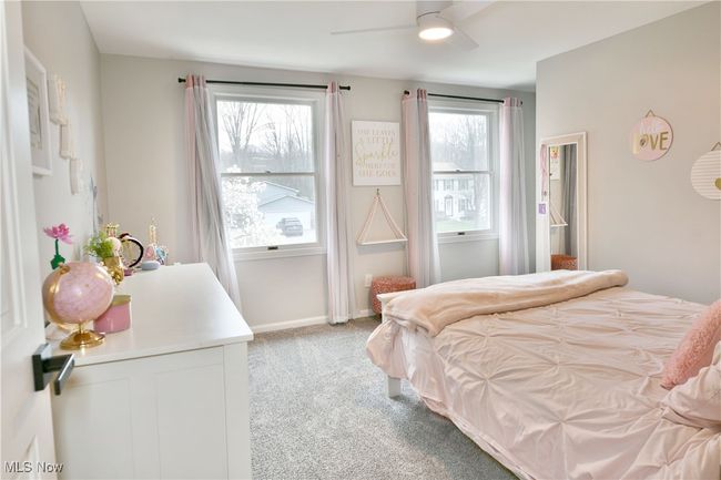 Bedroom with baseboards, multiple windows, light carpet, and a ceiling fan | Image 41