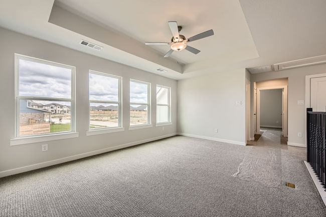 Unfurnished room with a tray ceiling, carpet floors, ceiling fan, and attic access | Image 25