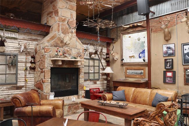 Living area with a fireplace and a towering ceiling | Image 28