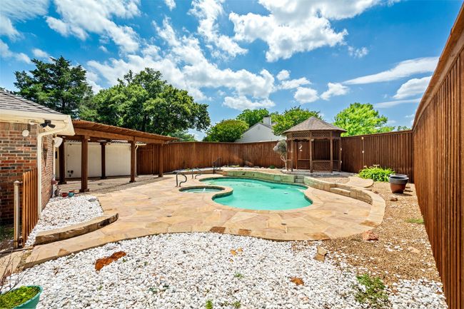 View of swimming pool featuring a gazebo, a fenced backyard, a patio, and a pool with connected hot tub | Image 27