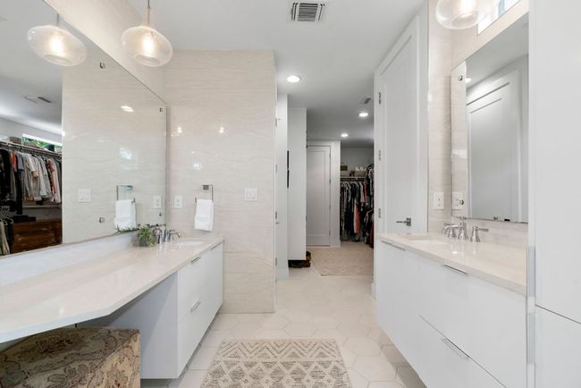 Tile floors & walls in the primary en suite bath. Floating vanities and oversized closet with a second laundry room. Primary on bottom floor. | Image 21