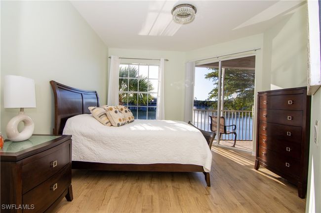 Primary bedroom overlooking the pond with slider to screened lanai. | Image 14