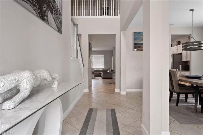 Entrance foyer with a high ceiling, light tile patterned flooring, and baseboards | Image 6