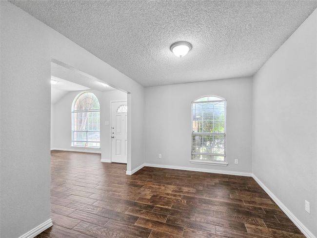 Spare room with plenty of natural light, dark wood-style floors, a textured ceiling, and baseboards | Image 11