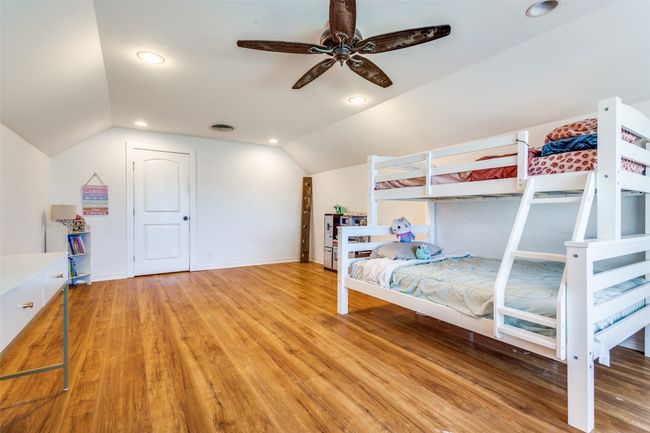 Expansive upstairs flex space with vaulted ceiling and natural light—ideal as a playroom, bunk room, secondary living area, or third bedroom with a large walk-in closet. | Image 17