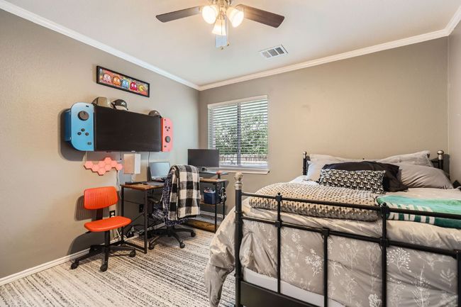 Bedroom with ornamental molding, an office area, and a ceiling fan | Image 18