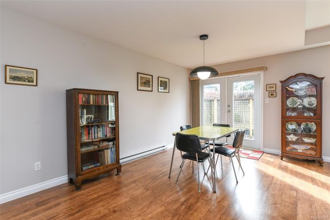 Dining space featuring a baseboard heating unit, wood finished floors, a fireplace, a ceiling fan, and recessed lighting | Image 7