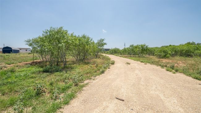 View of dirt / gravel road with a rural view | Image 6