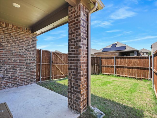 Fenced backyard with a patio area and a gate | Image 21