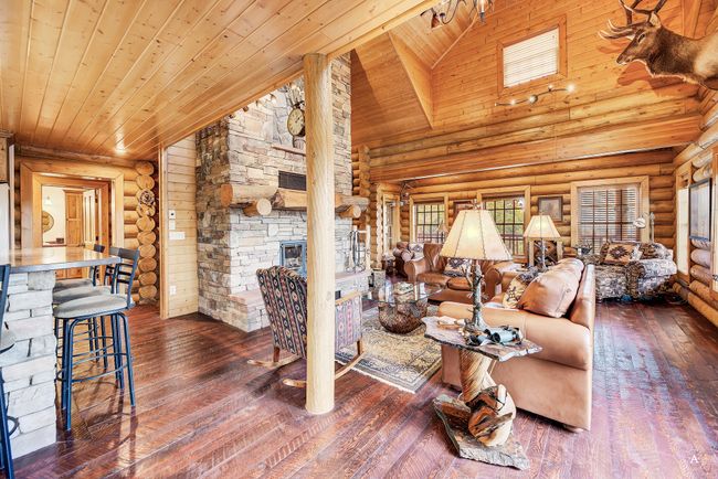 Living room with log walls, wood ceiling, hardwood / wood-style flooring, a fireplace, and high vaulted ceiling | Image 8