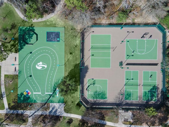 The vibrant Spring Trails community sports court features versatile recreational spaces, including tennis courts and a multi-use area, catering to active living. Surrounded by lush pathways and scenic greenery, it offers an inviting setting for sport enthusiasts and leisurely walks. | Image 44