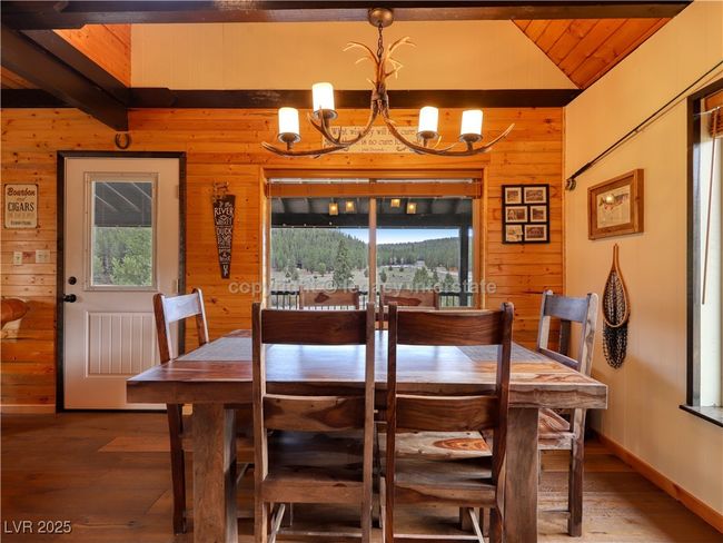 Dining area with wood walls, wood finished floors, wooden ceiling, beamed ceiling, and an inviting chandelier | Image 14