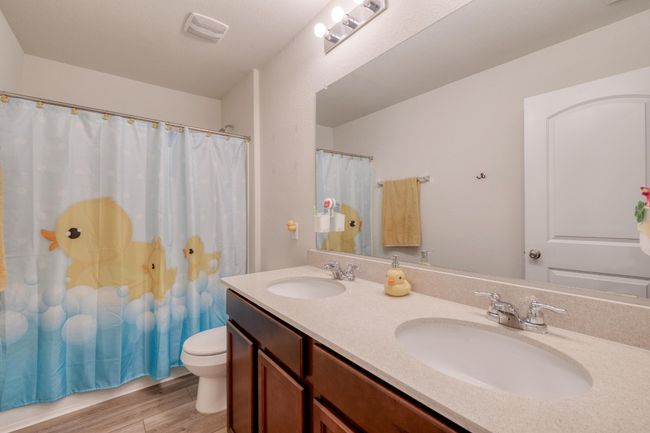 Bathroom featuring double vanity, wood finished floors, toilet, and a sink | Image 28