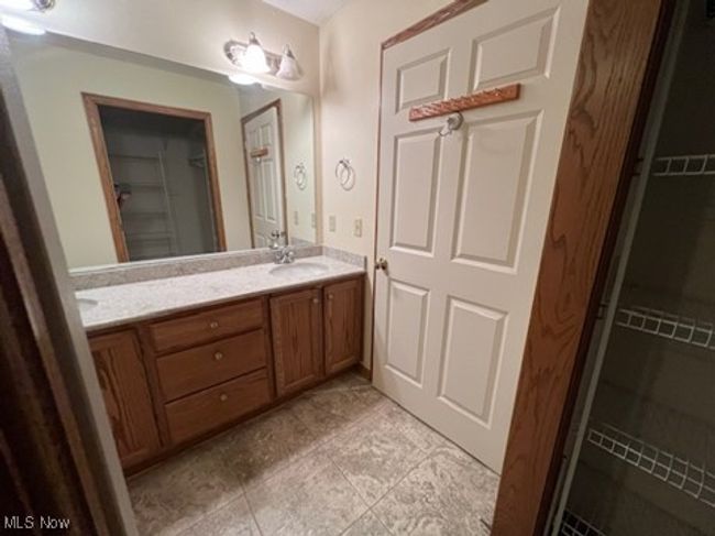 Full bathroom with double vanity, a spacious closet, and tile patterned flooring | Image 17