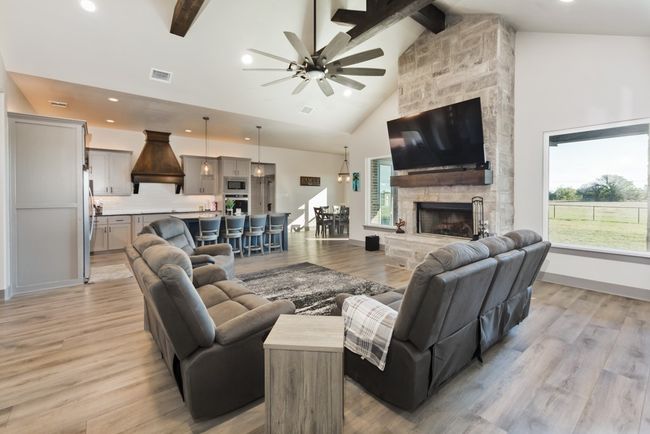 Living room with ceiling fan, light wood-type flooring, beam ceiling, and visible vents | Image 20