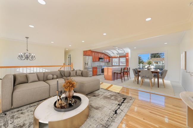 Living room with crown molding, light hardwood / wood-style floors, and a chandelier | Image 24