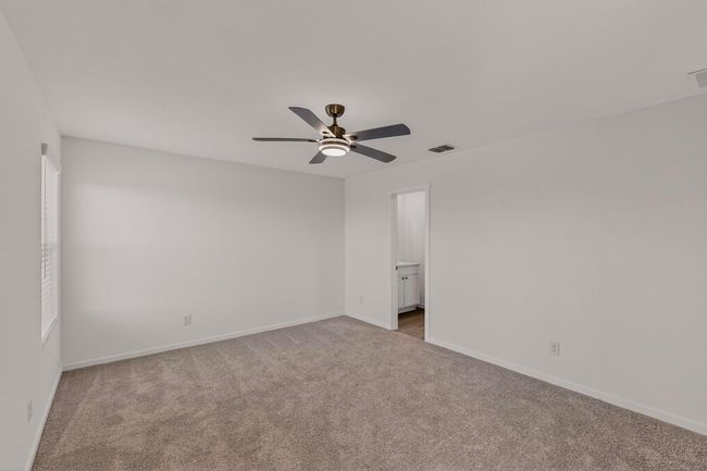 Carpeted spare room featuring ceiling fan and baseboards | Image 18