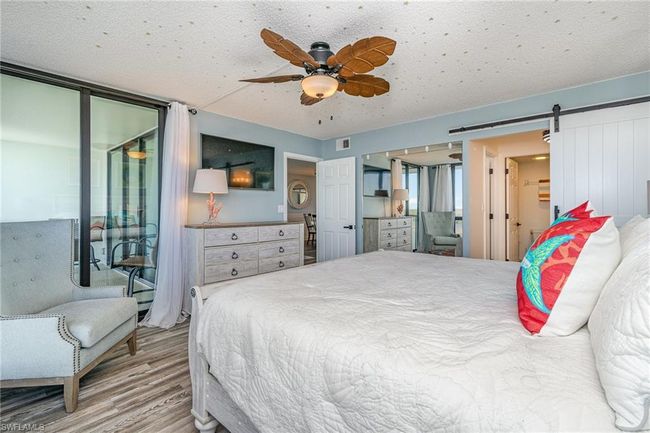 OWNER'S SUITE. ENTRANCE TO EN-SUITE BATH SHOWN MIDDLE RIGHT. TRACK BARN DOOR. CUSTOM LARGE MIRROR. UPDATED CEILING FAN. | Image 15