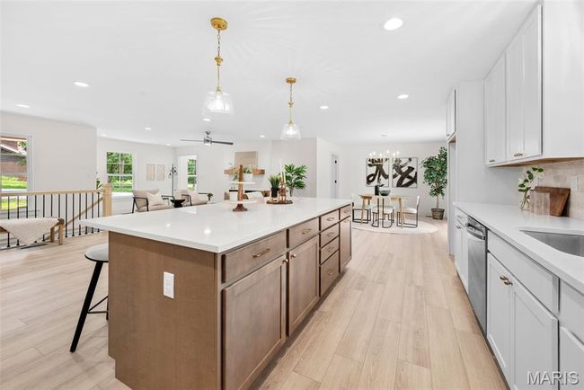 Kitchen with light wood finished floors, a center island, recessed lighting, a breakfast bar, and stainless steel dishwasher | Image 18