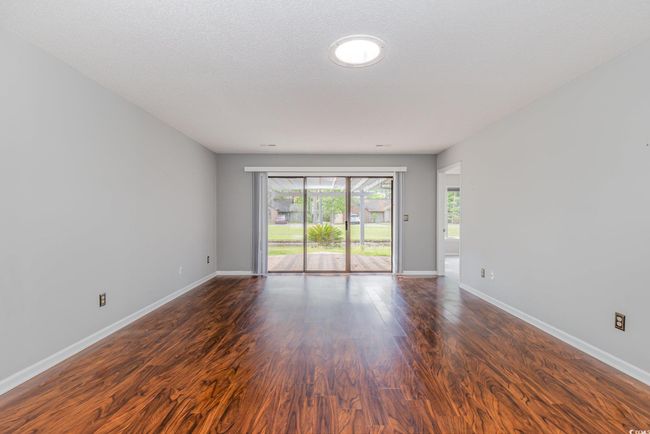 Unfurnished room with baseboards and dark wood-style flooring | Image 7