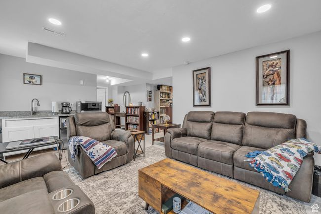 Living area featuring light carpet, recessed lighting, and wet bar | Image 23