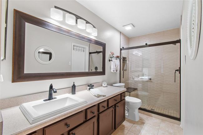 Primary bathroom updated with a sliding glass shower door and beautiful tile. | Image 14