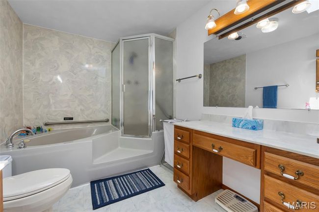 Full bath featuring a bathtub, vanity, an enclosed shower, and marble look tile flooring | Image 72