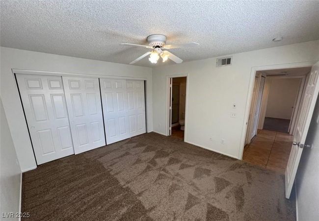 Unfurnished bedroom with carpet floors, a closet, a textured ceiling, a ceiling fan, and baseboards | Image 6