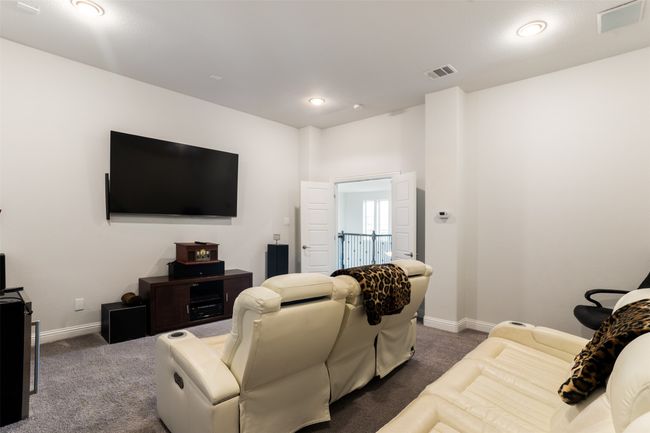 Living room with dark colored carpet, visible vents, and baseboards | Image 28