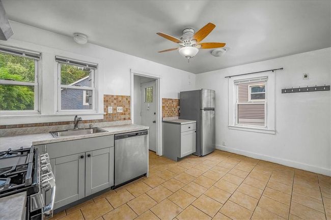 Unit # 68 Kitchen with gray cabinetry, tasteful backsplash, sink, and stainless steel appliances | Image 10
