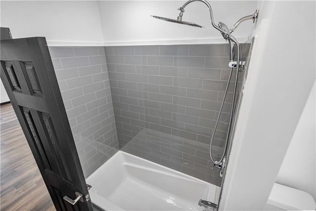 Full bath featuring toilet, shower / tub combination, and wood finished floors | Image 32