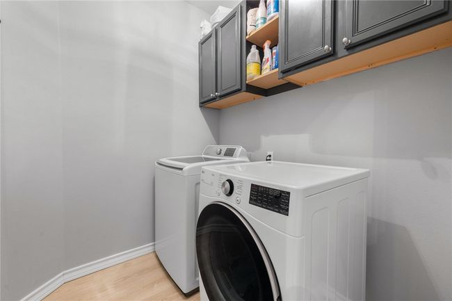 The laundry room is located inside the home with upper cabinetry for general storage. | Image 22