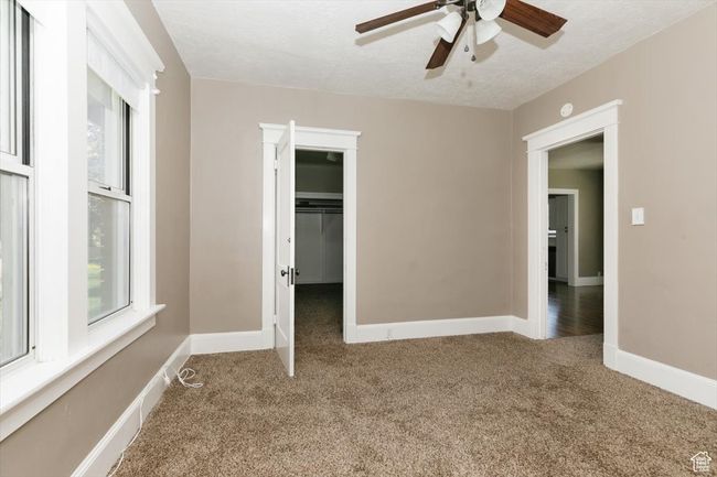 Interior space with a textured ceiling, visible vents, baseboards, and concrete flooring | Image 19