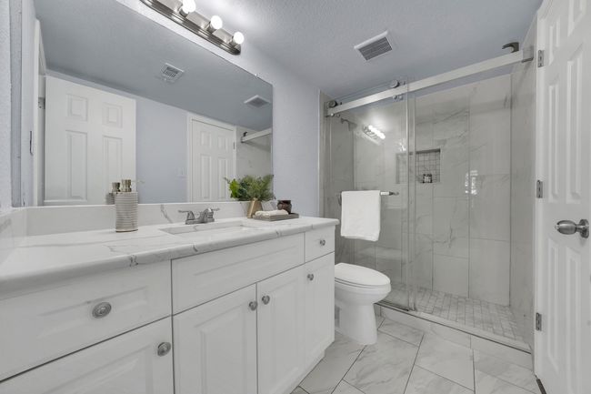 Bathroom with vanity, a marble finish shower, marble finish floors, and a textured ceiling | Image 34