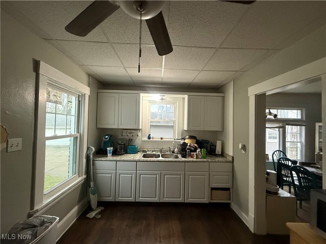 Kitchen featuring dark wood-style flooring, a paneled ceiling, a ceiling fan, and a sink | Image 14