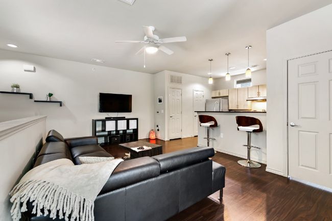 Living area with dark wood finished floors, ceiling fan, and recessed lighting | Image 4