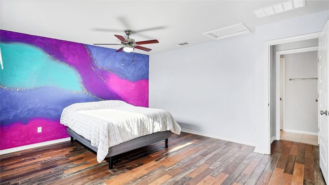 Bedroom with attic access, baseboards, wood finished floors, and visible vents | Image 18