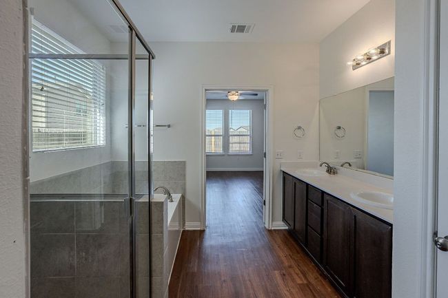 Bathroom featuring a sink, a garden tub, visible vents, double vanity, and wood finished floors | Image 10