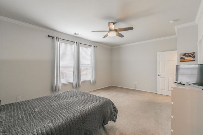 Carpeted Main bedroom with ceiling fan and ornamental molding | Image 29