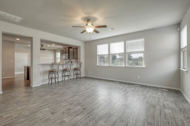 Unfurnished living room with ceiling fan, wood finished floors, and recessed lighting | Image 5