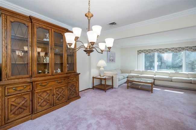 Living room featuring visible vents, light carpet, an inviting chandelier, and ornamental molding | Image 12